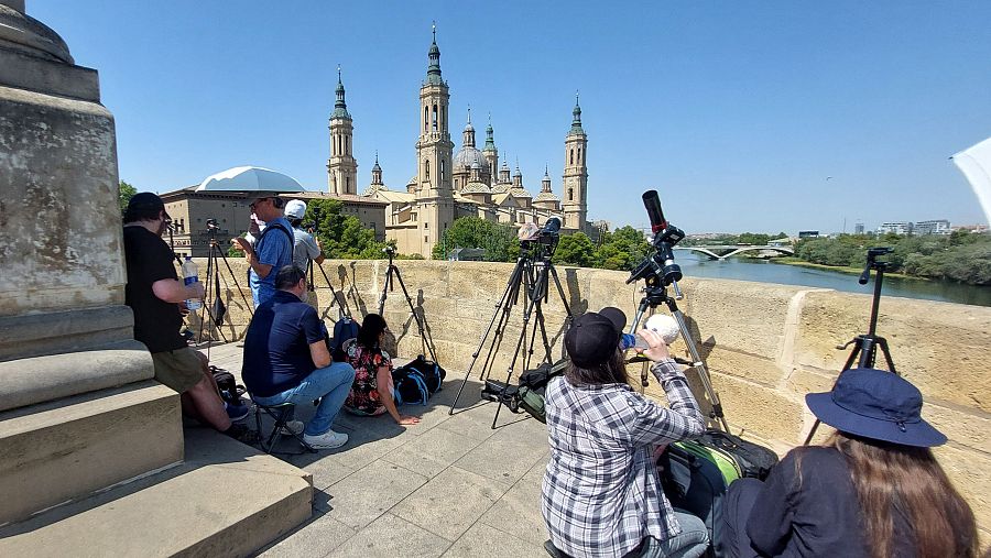 Varias personas se han instalado en el Puente de Piedra de Zaragoza para disfrutar del eclipse