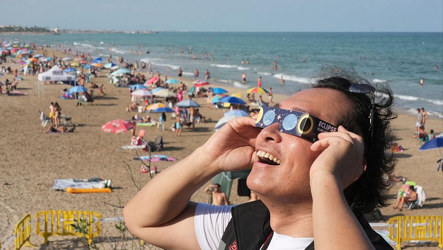 Un hombre luce sus gafas homologadas en una playa de Valencia