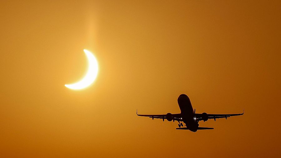 Un avión despega del aeropuerto de Manises (Valencia), durante el eclipse solar