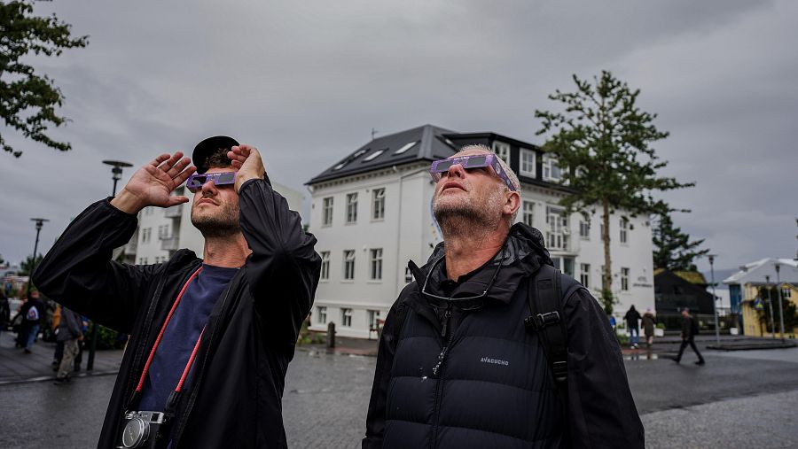Personas usando gafas especiales para eclipses solares en Reikiavik, Islandia