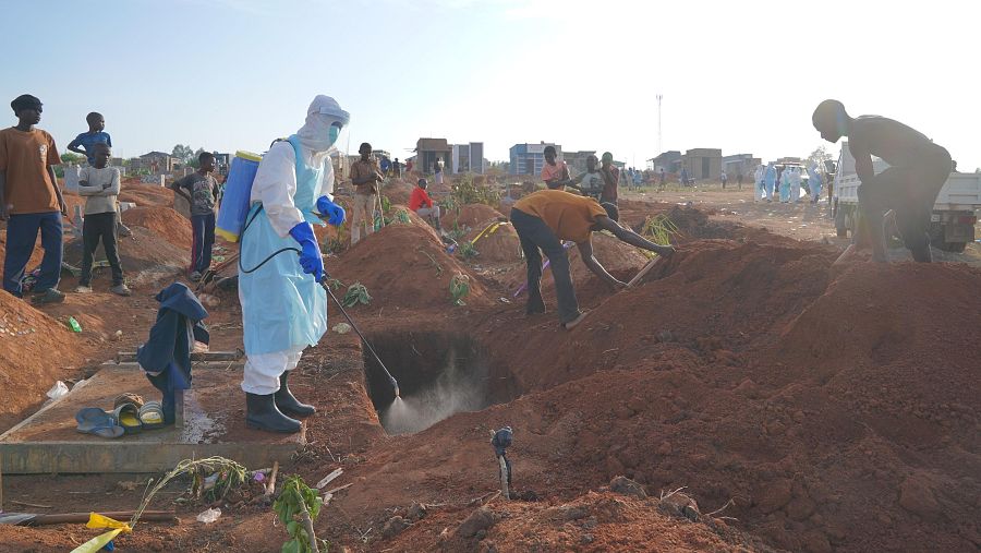 Un trabajador sanitario rocía desinfectante en una tumba recién cavada para un muerto por ébola en Bunia, provincia de Ituri, al este del Congo.