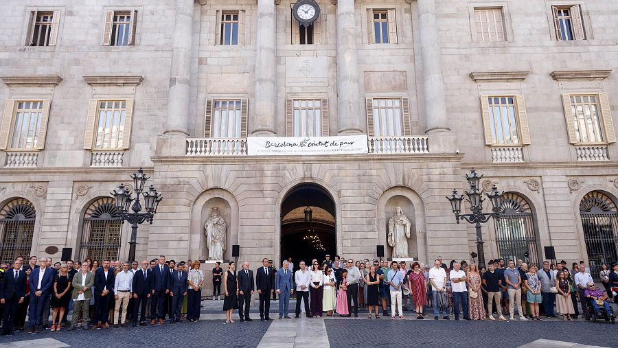 Familiares, víctimas y representantes de las instituciones, en la plaza de Sant Jaume de Barcelona para conmemorar el noveno aniversario de los atentados del 17-A.