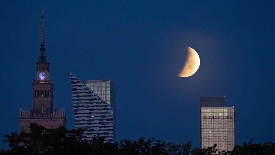 La luna llena se pone sobre los rascacielos de Varsovia durante el eclipse lunar parcial