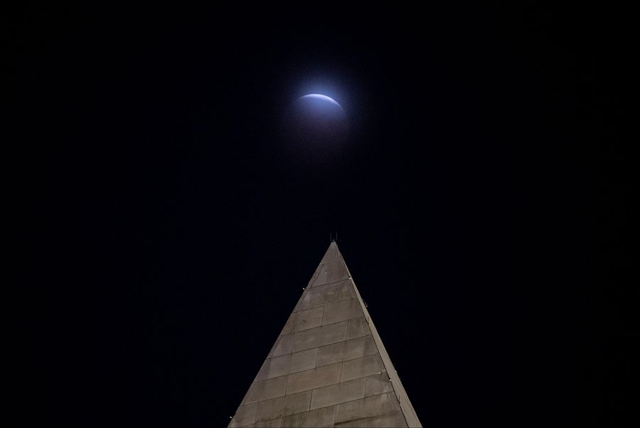 Eclipse lunar a través de las nubes detrás del Monumento a Washington