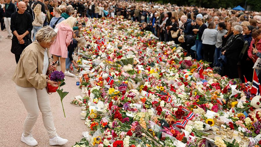 Cientos de personas depositan flores, banderas y velas en un memorial para el rey Harald