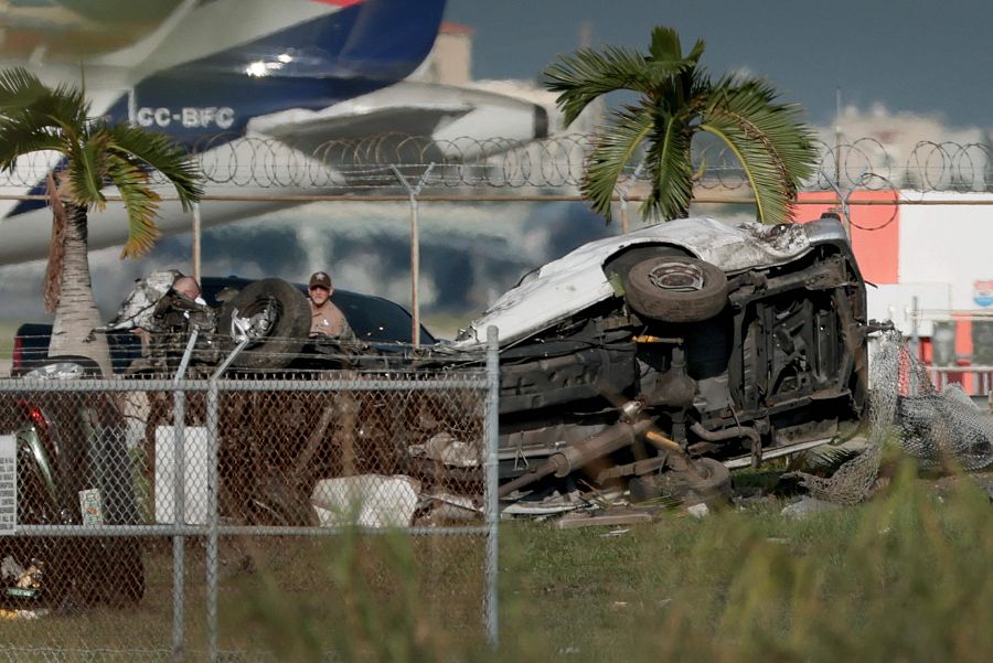 Investigadores caminan cerca de vehículos dañados en el Aeropuerto Internacional de Miami