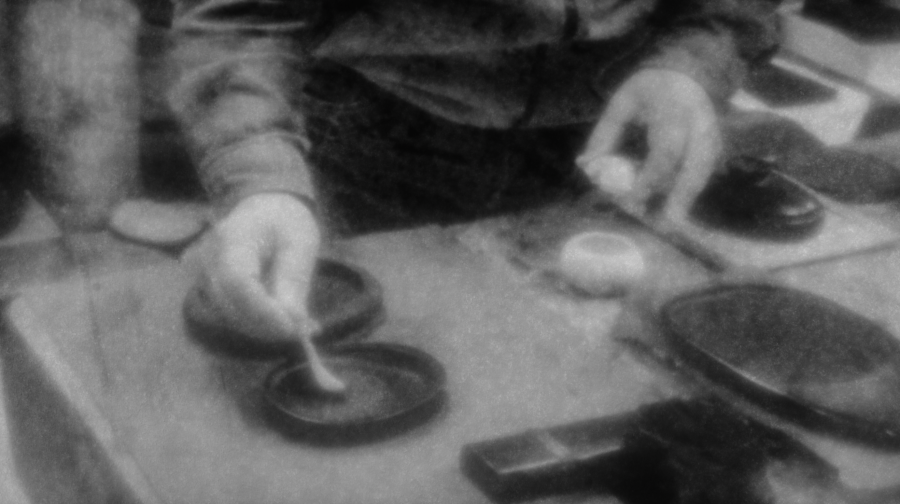 Imagen en blanco y negro de un calígrafo japones preparando la tinta