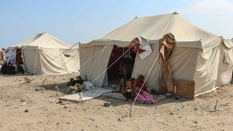 Personas desplazadas fuera de su tienda de campaña en el campamento de desplazados de Al-Farsi en Ras Imran, en el suroeste de Adén.