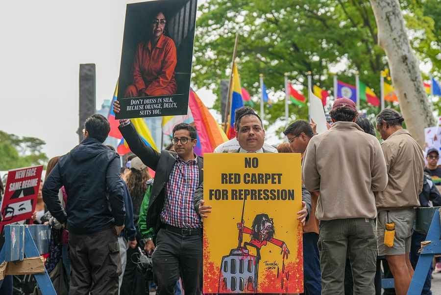 Personas sostienen carteles en contra de la presidenta encargada de Venezuela, Delcy Rodríguez