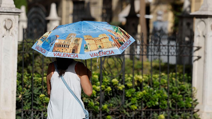 Una mujer se protege del sol con un paraguas en València