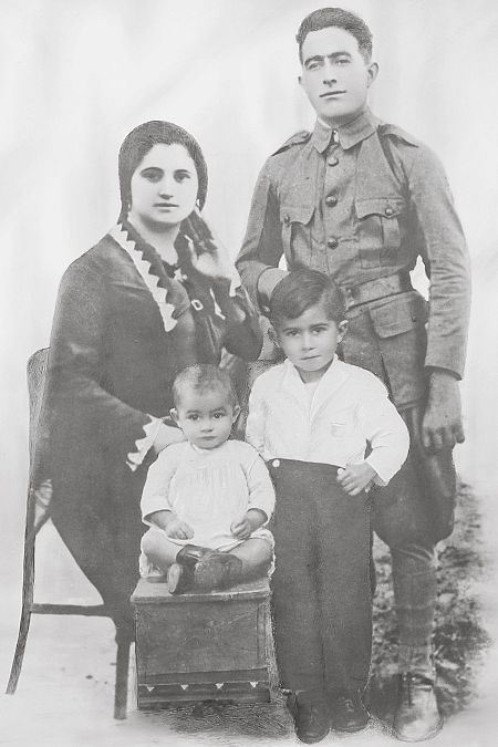 Retrato familiar en blanco y negro de cuatro personas: dos adultos y dos niños. El hombre luce un uniforme militar de principios del siglo XX. La imagen evoca un sentido de unidad familiar y un pasado histórico.