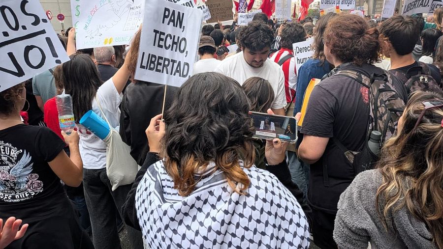 Una manifestante fuera del Congreso sigue la intervención de la portavoz de Junts, Míriam Nogueras, en el Canal 24 Horas de TVE