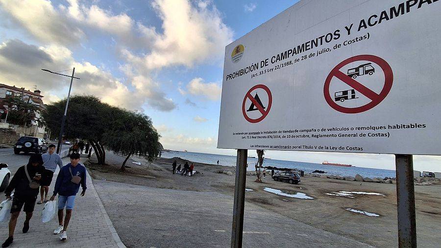 Cientos de jóvenes caminan por aceras y arcenes junto al mar en la costa ceutí.