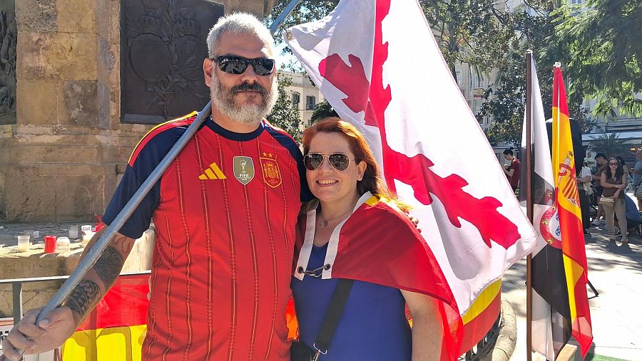 Jesús y Sandra portan la bandera con la Cruz de Borgoña.