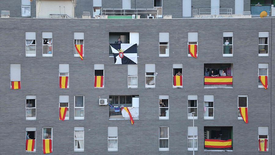 Banderas de España y Ceuta ondean en las ventanas de los edificios frente al cementerio de Sidi Embarek en Ceuta