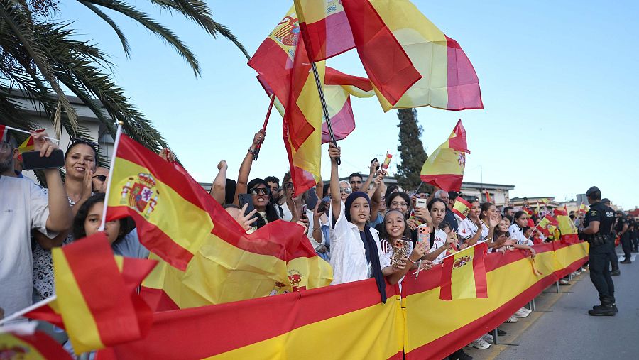 Ceutíes ondean la bandera de España esperando el paso de los reyes, este martes por la tarde