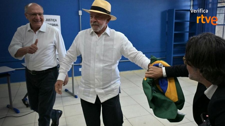 Lula da Silva entrega la bandera brasileña a su fotógrafo, Ricardo Stuckert.