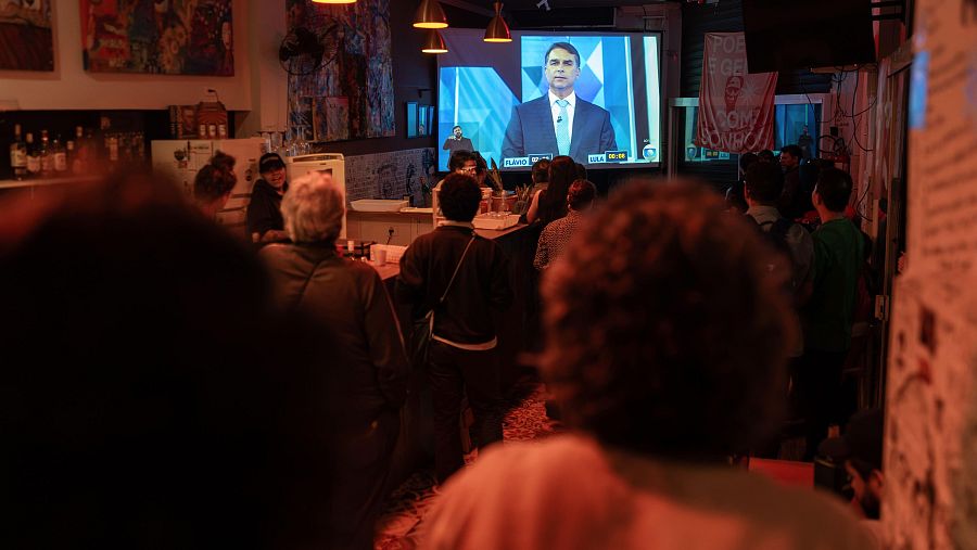 Personas observan una trasmisión del debate entre el presidente de Brasil y candidato a la reelección, Luiz Inácio Lula da Silva, y el candidato de la oposición Flávio Bolsonaro.