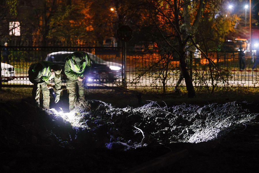 Funcionarios ucranianos inspeccionan un cráter en el lugar de un ataque con misiles rusos contra una zona residencial en Kiev