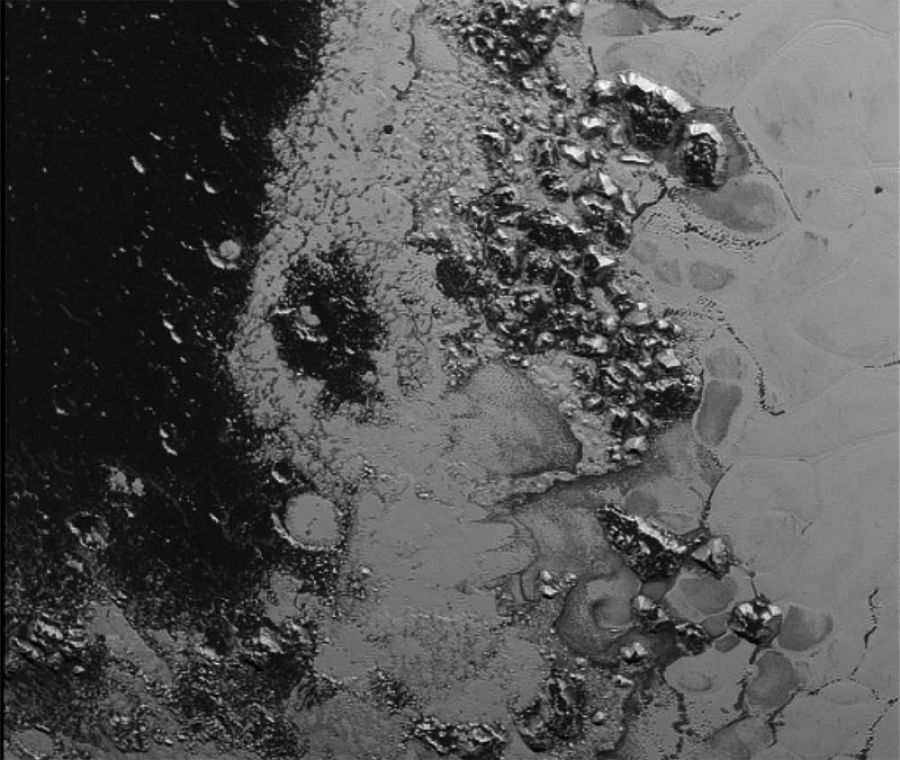 Una nueva cadena montañosa de hielo en el límite entre la intrigante llanura helada Sputnik y otra zona oscura cubierta de cráteres