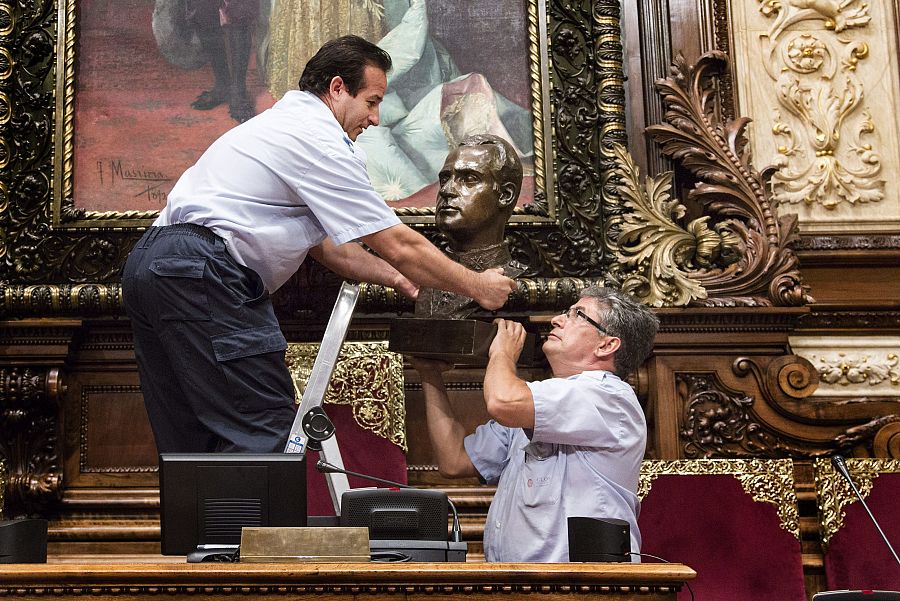 Dos operarios municipales retiran el busto de Juan Carlos I