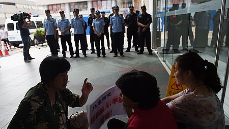 Familiares de los pasajeros del avión de Malaysia Airlines MH370 protestan frente a las oficinas