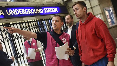 Un trabajador de metro informa a un viandante a dónde dirigirse para conseguir transporte alternativo