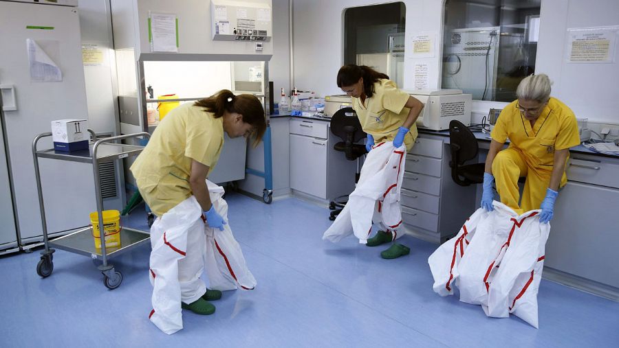 Tres investigadoras se ponen los trajes protectores antes de entrar al laboratorio de alta seguridad P-3 del Instituto de Salud Carlos III