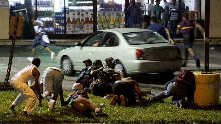 Varios manifestantes corren en Ferguson para protegerse tras escuchar disparos de la Policía