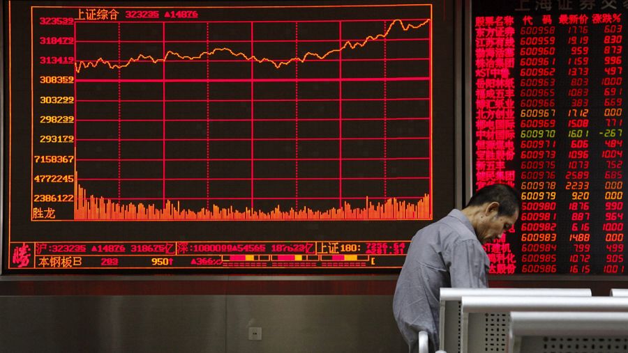 Inversores observan la información bursátil en una pantalla en una oficina de corretaje en Pekín