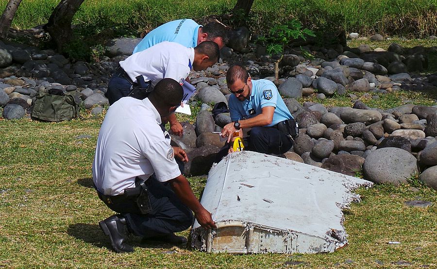 Gendarmes franceses inspeccionan los restos del Boeing 777 en La Reunión. 