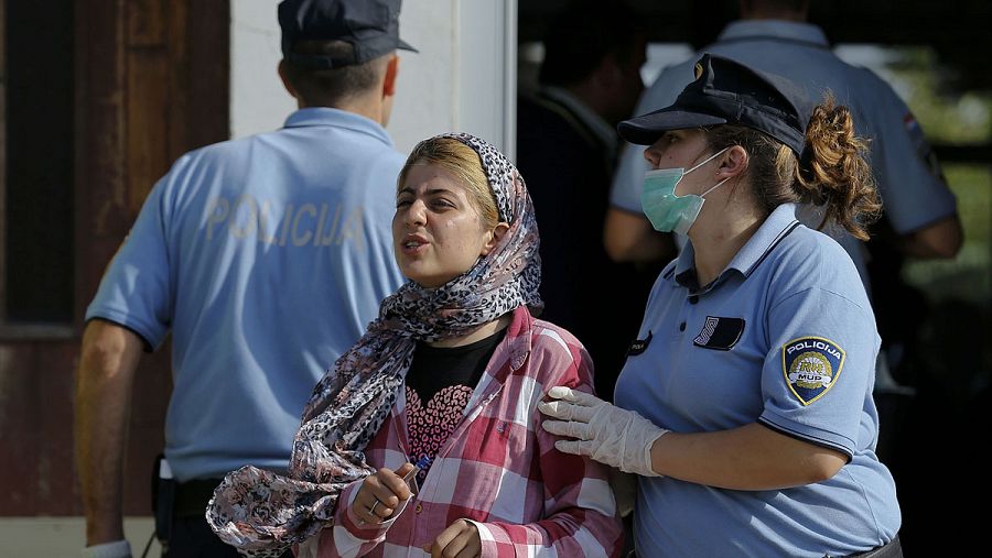 Una agente de Policía croata con una refugiada en Tovarnik, Croacia. REUTERS/Antonio Bronic