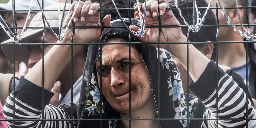 Una migrante sobre una valla metálica en el pueblo de Horgos en la frontera entre Hungría y Serbia