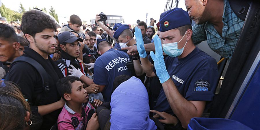 La policía húngara vigila el envío de refugiafos a autobuses en la frontera entre Hungría y Croacia en la localidad de Beremend,