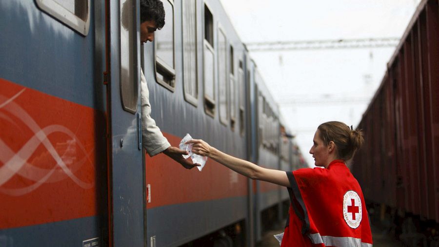 Una voluntaria de Cruz Roja ayudando a un refugiado