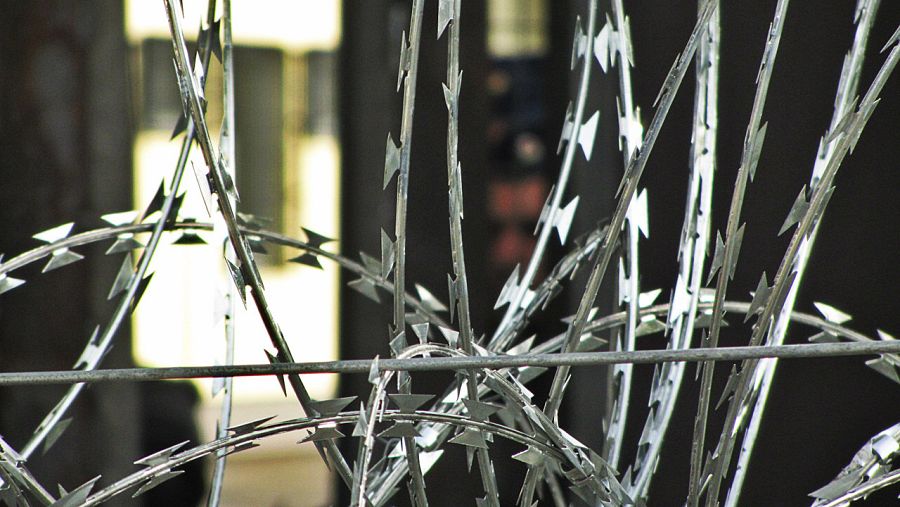 La maraña de concertinas que no amenazan, sino que cortan el paso directamente. Al fondo, un policía húngaro. Horgos (Serbia), frontera con Hungría. J.C.Gallardo