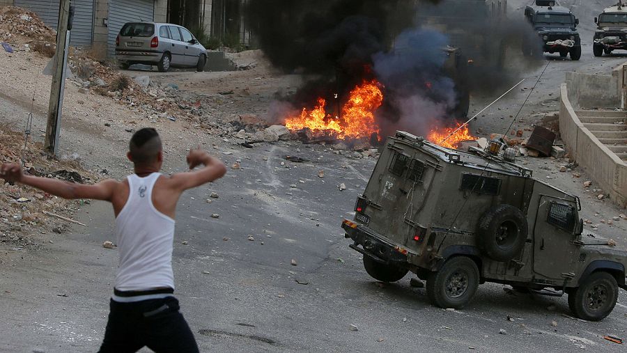 Un joven palestino arroja piedras contra los vehículos de los soldados israelíes en Nablus, Cisjordania, el 6 de octubre de 2015 AFP PHOTO / JAAFAR ASHTIYEH