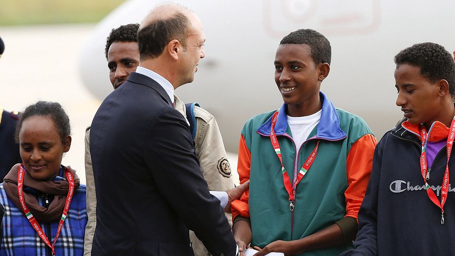 El ministro de Interior italitano, Angelino Alfano, saluda a los refugiados eritreos antes de que partan desde Roma a Estocolmo. REUTERS/Remo Casilli
