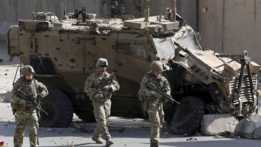 Varios soldados de la OTAN rodean uno de los vehículos militares de la misión de la Alianza atacados por un suicida este domingo en Kabul.