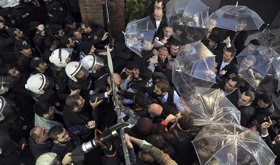 Policías antidisturbios y empleados del periódico Bugün y del canal Kanalturk se enfrentan en las oficinas de los medios en Estambul. AFP PHOTO / ZAMAN DAILY / MEHMET ALI POYRAZ