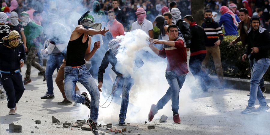 Manifestantes palestinos lanzan piedras contra soldados israelíes durante enfrentamientos en la ciudad cisjordana de Hebrón