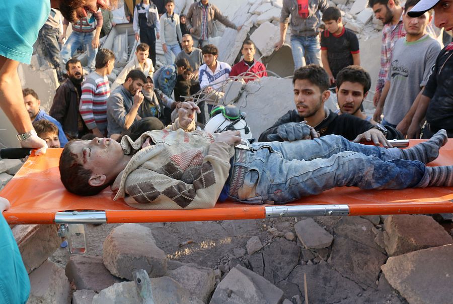 Traslado en camilla de un chico herido en los bombardeos sobre Alepo