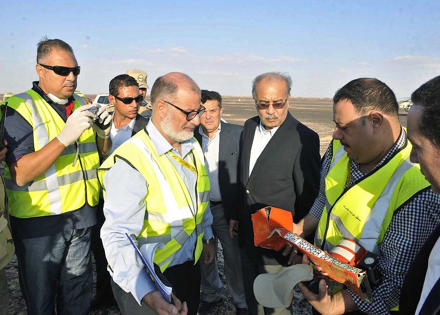 El primer ministro egipcio, Sherif Ismail, examina en el lugar del siniestro la caja negra del avión.