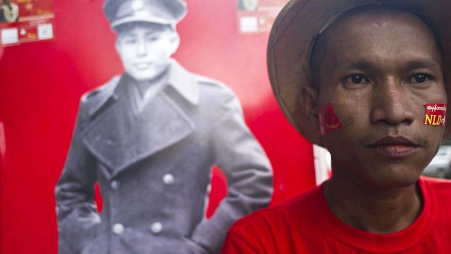 Un partidario del partido opositor Liga Nacional por la Democracia frente a un retrato del héroe de la independencia Aung San, padre de Aung San Suu Kyi. AFP PHOTO / Ye Aung THU
