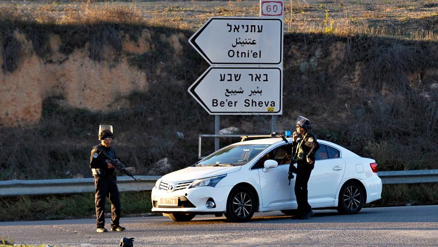 Soldados israelíes montan guardia en un cruce de Hebrón cercano al lugar donde han sido tiroteados dos colonos