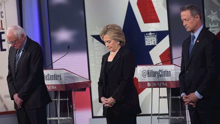 De izquierda a derecha, los candidatos demócratas Bernie Sanders, Hillary Clinton, y Martin O¿Malley guardan un minuto de silencio por los atentados en París, durante el debate de las primarias. AFP/Mandel Ngan