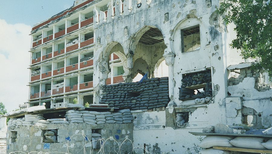 Edificio en ruinas con la bandera de la ONU en Mogadiscio, Somalia, en 1995. Fuente: TVE