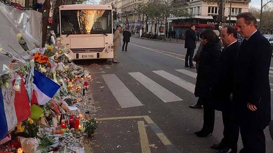 El primer ministro británico, David Cameron, y el presidente francés, François Hollande, depositan flores ante la sala de fiestas Bataclan, uno de los escenarios de los atentados de París