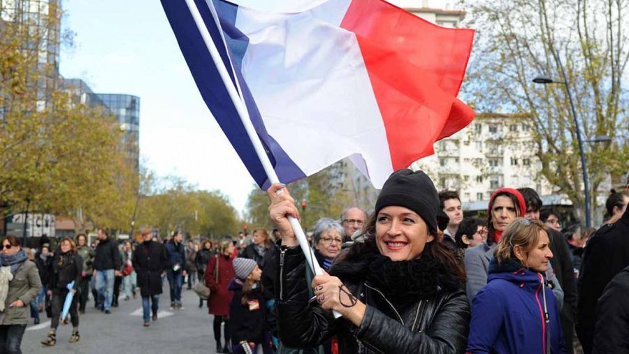 Una mujer porta una bandera francesa en una de las múltiples marchas en memoria de las víctimas de los atentados de París.
