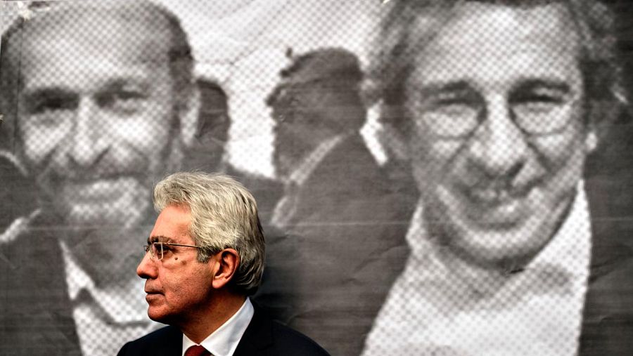 Un hombre se apoya sobre una imagen de Erdem Gül y Can Dündar en la sede del diario 'Huriyet'